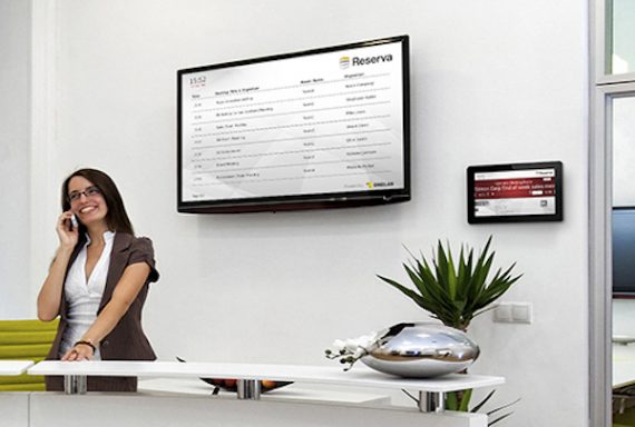 Cheerful front desk lady doing her job with passion. The black space on the TV-screen could be used for any logos, some label signs or any graphic additions.